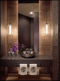 a bathroom with two lights and a sink in the middle, along with towels on the counter