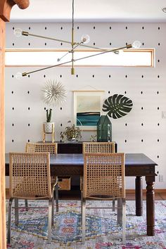 a dining room table with four chairs and a rug