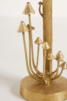 a group of gold colored mushrooms sitting on top of a wooden stand