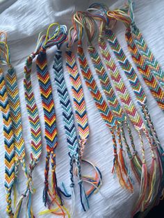 several different colored braids laid out on top of a white cloth covered tablecloth