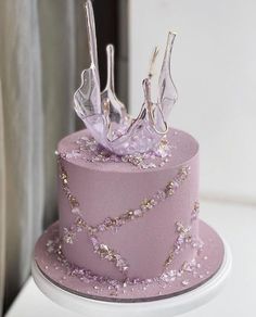 a purple cake with silver decorations on top and frosting in the shape of forks