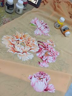 the table is covered with many different types of paint and flowers on it, including peonies