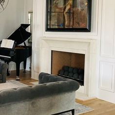 a living room filled with furniture and a piano in front of a painting on the wall