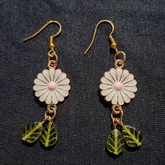 Introducing our beautiful custom-made White Flower and Olive Green Leaf Earrings, available exclusively on Etsy! These earrings are perfect for any occasion and a great addition to your spring/summer accessories. Each earring features a stunning white enamel flower with a gold tone metal backing, and a pair of gorgeous olive green Czech glass leaves hanging below the flower. Our earrings are made with hypoallergenic gold tone metal and high-quality materials, ensuring durability and longevity. Y Jewelry Making Earrings, Metal Spring, Enamel Flower, Earrings White, Spring Flower, Green Leaf, Summer Accessories, White Enamel, Leaf Earrings