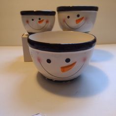 three bowls with faces painted on them sitting next to each other, one has an orange nose