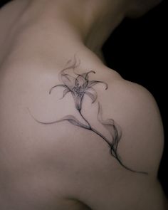 a woman's shoulder with a flower tattoo on it