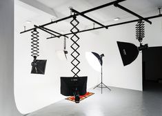 an empty room with lighting equipment hanging from the ceiling