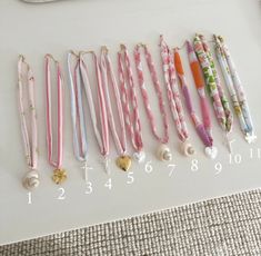 several different colored lanyards are lined up on a white table with the numbers 1, 2, 3, 4, 5, and 6