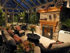 a living room filled with furniture and a fire place in the middle of an open floor plan