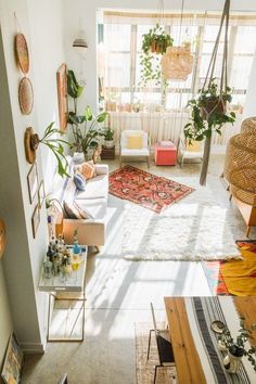 a living room filled with lots of furniture and plants