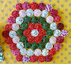 an arrangement of red, white and green pinwheels on a yellow tablecloth