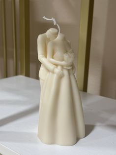 a white wedding cake topper with a bride and groom on it's side