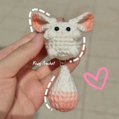 a small crocheted animal is being held in someone's hand with the key chain attached to it