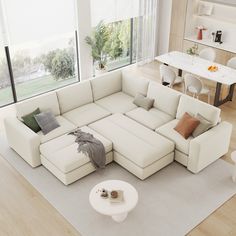 a living room with a large white sectional couch and coffee table in the center area