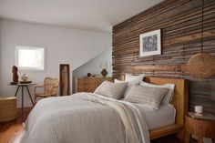 a bed sitting in a bedroom next to a wooden wall