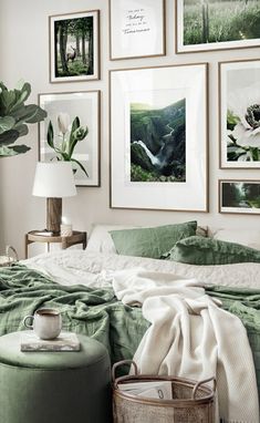 a bedroom with green bedding and pictures on the wall above it, along with a round ottoman