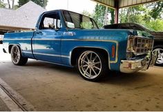 an old blue truck parked in a garage