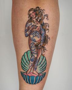 a woman's leg with a tattoo on it and an image of a mermaid