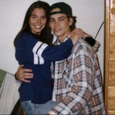 two people hugging each other while sitting on a bed