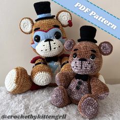 two crocheted teddy bears sitting next to each other on a white bed sheet