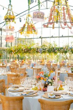 an outdoor dining area with tables, chairs and chandeliers hanging from the ceiling