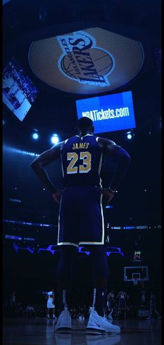 a basketball player standing in the middle of a court with his hands on his hips