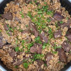 a pot filled with rice and meat on top of a table