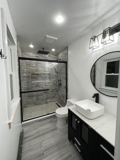 a bathroom with a sink, toilet and shower stall in the middle of the room