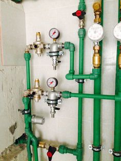 green pipes and gauges are lined up on the wall