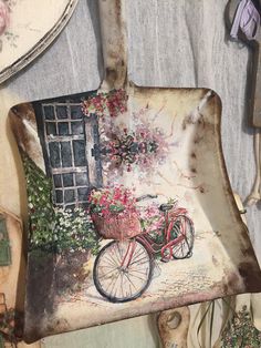 an old wall hanging with flowers and a bicycle painted on it