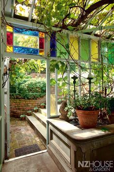 the inside of a greenhouse with potted plants and stained glass windows on the walls