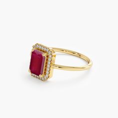 a gold ring with a red stone and diamonds