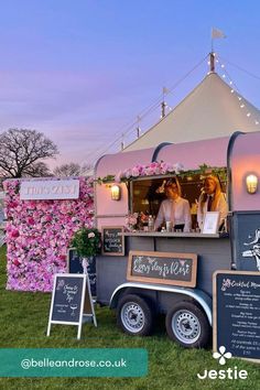 the food truck is decorated with pink flowers