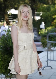 a woman in a white dress is posing for the camera with her hand on her hip