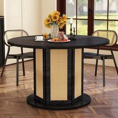 a dining table with chairs around it and flowers in vases on the table top