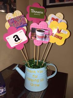 a blue watering can filled with lots of stickers on top of a wooden table