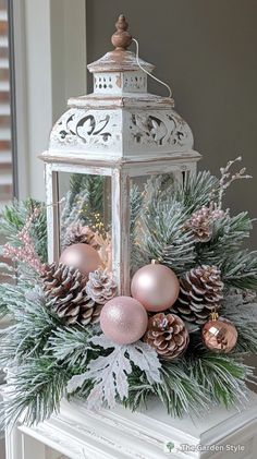 a white lantern with pine cones and ornaments