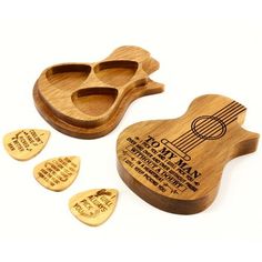 three wooden guitar picks and one is shaped like a guitar picker with four holes in it