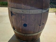 a large wooden barrel sitting on top of a cement floor