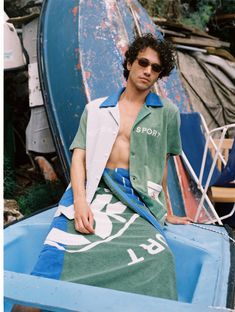 a man sitting on top of a surfboard next to a blue and green object