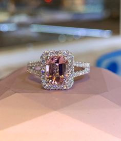 a fancy ring with an orange and white diamond surrounded by smaller diamonds on top of it