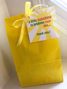 a yellow paper bag with a note attached to it that says, a little sunshine is to brighten your day thank you