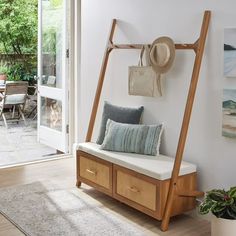 a room with a bench, hat rack and other items on the wall next to it