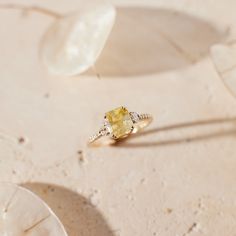 a yellow diamond ring sitting on top of a table