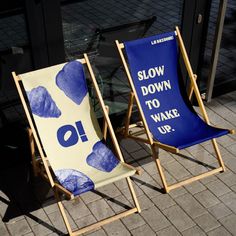 two lawn chairs sitting next to each other on a sidewalk