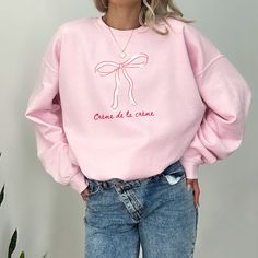 Crème de la crème pink bow crewneck sweatshirt  Sweatshirt Info: ::fabric is 3-end garment-dyed, ring-spun, color-blast fleece with a 100% cotton face.  ::80% ring-spun cotton, 20% polyester ::Medium-heavy fabric  ::Relaxed fit ::Sewn in twill label ::OEKO-TEX certified low-impact dyes FAQs: -Please allow 7 business days for the garment to arrive as it's made to order.  -We do not accept returns due to each shirt being made to order however, if there is an issue please reach out - we're happy to help.  Washing Instructions:  -Please wash garment inside out in cold water with like colors, this protects the integrity of the shirt so it's enjoyed for years to come.  Goldfinch Clothing Co was birthed out of the desire to empower women to step into exactly who they are, unapologetically. Meldin Pink Crew Sweatshirt For Spring, Pink Crew Neck Sweatshirt For Spring, Cute Pink Cotton Sweatshirt, Cute Pink Crew Neck Sweatshirt, Crew Neck Cotton Top With Pink Bow, Cotton Crew Neck Top With Pink Bow, Clothing Branding Design, Bow Sweatshirt, Hoodie Weather