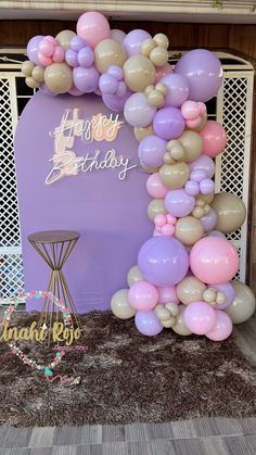 the balloon arch is decorated with pink, white and purple balloons that spell happy birthday