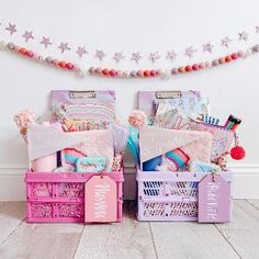 two children's toys are stacked on top of each other in pink and purple crates