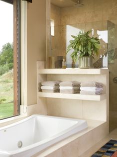 a bathroom with a large bathtub next to a window and a rug on the floor