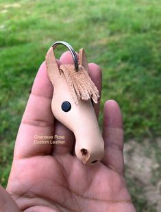 a hand holding a small horse shaped keychain